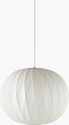 a white light hanging from a ceiling fixture with an intricate pattern on it's surface