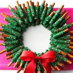 a christmas wreath made out of pretzels with a red bow on it's front