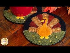 two placemats with a turkey on them sitting on a wooden table next to a red cup