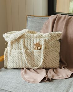 a purse sitting on top of a couch next to pillows