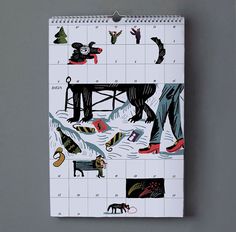 a calendar with an image of people and animals on it, sitting in front of a gray wall