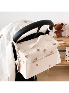 a white bag sitting on top of a wooden table next to a teddy bear and other items