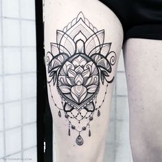 a woman's thigh with a black and white tattoo design on it