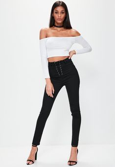 a woman in black pants and white top posing with her hands on her hipss