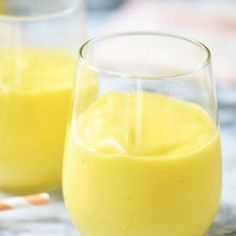 two glasses filled with orange juice on top of a table