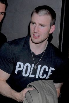 a man in a police t - shirt is looking at something