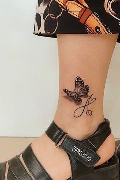 a woman's foot with a tattoo on the ankle that has a small butterfly