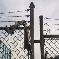 a fence that has some kind of cloth on top of it and barbed wire behind it