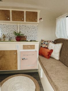 a living room filled with furniture next to a window and a rug on top of a hard wood floor