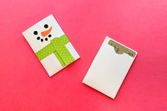 two pieces of paper cut out to look like a snowman on pink background with clippings