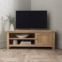 a wooden entertainment center with a flat screen tv on it's stand in a living room