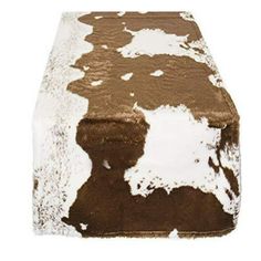 a brown and white cowhide footstool on a white background