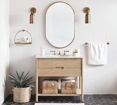 a bathroom with a sink, mirror and plants in baskets on the floor next to it