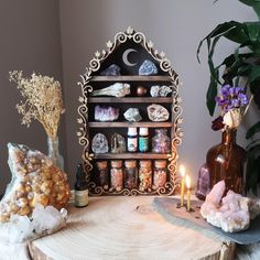 a wooden table topped with lots of rocks and candles