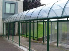 a large green building with lots of glass on the side of it's roof