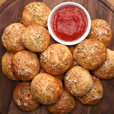 a plate full of bread rolls with ketchup on the side and some sprinkled parmesan cheese