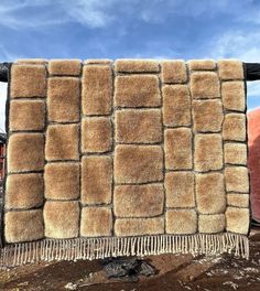 a brown and black blanket sitting on top of a pile of dirt