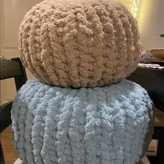 two pillows stacked on top of each other in front of a dining room table and chair