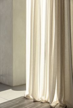 an open window with white curtains and the sun shining through it's drapes