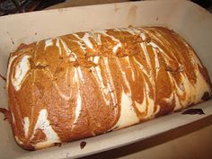 a loaf of bread sitting on top of a white paper tray covered in icing