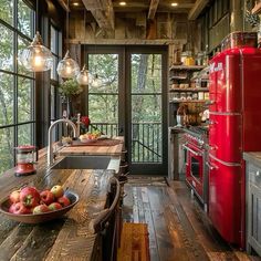 a rustic kitchen with red appliances and wood flooring is pictured in this image from the inside