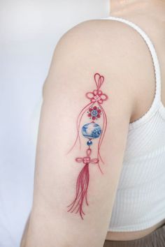 a woman's arm with a tattoo on it that has flowers and a bell