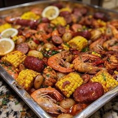 a pan filled with shrimp, corn and potatoes