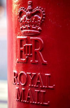 the royal mail box is painted red and has a crown on it's top