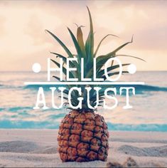 a pineapple sitting on top of a sandy beach next to the ocean with words hello august above it