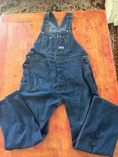 Vintage Blue Denim Bib Overalls  Size Large 42 x 32  See pics for measurements  Quality Big Smith Brand  Made in USA  Perfect slightly faded natural patina with a few bleach stains as pointed out in pics  Fine condition  Quick shipping.  We ship same or next day with USPS MAIL  We are a small family business and we appreciate your purchase, Godspeed ! Vintage Denim Overalls, Big Smith Overalls, Vintage Fitted Medium Wash Overalls, Denim Blue Retro Overalls, Blue Fitted Vintage Overalls, Vintage Dark Wash Overalls, Vintage Dark Wash Bib Front Overalls, Overalls Denim, Overalls Vintage