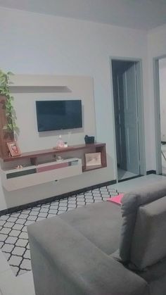 a living room filled with furniture and a flat screen tv mounted on the wall above it