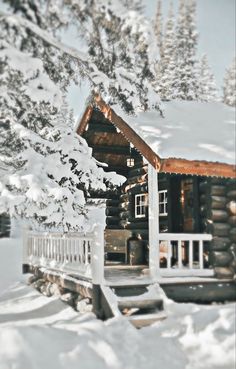 a log cabin in the snow with stairs leading up to it