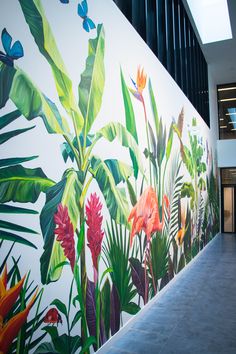 a large mural on the side of a building with flowers and plants painted on it