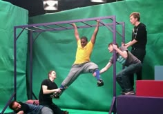 three men are performing on stage with one man upside down and the other standing up