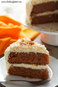 a slice of carrot cake on a white plate with a fork in front of it