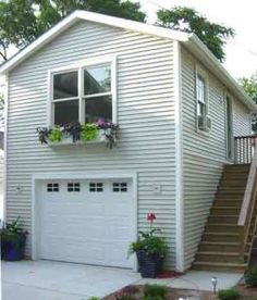 a two story house with stairs leading up to the garage