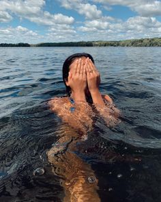 a person floating in the water covering their eyes