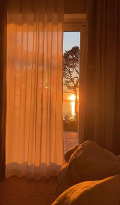 the sun is shining through the curtains in this bedroom