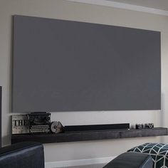 a living room with a large gray screen on the wall