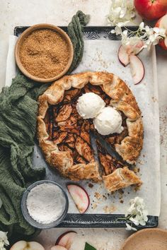 an apple pie with ice cream on top and some other food items around the edges