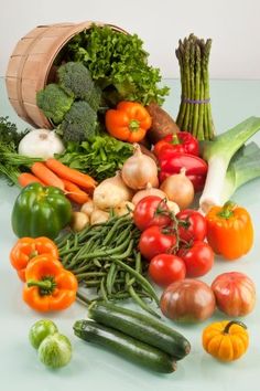 an assortment of fresh vegetables including tomatoes, asparagus, broccoli and zucchini