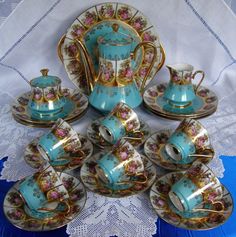 a blue and gold tea set with matching cups and saucers