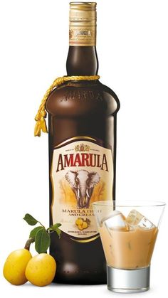 a bottle of amarula next to a shot glass and lemons on the table