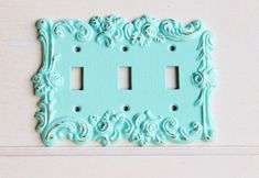 two light switch plates are painted aqua blue