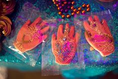 three pairs of pink gloves sitting on top of a table next to beaded beads