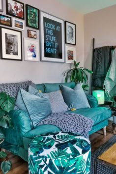 a living room filled with green furniture and pictures on the wall above it's headboard