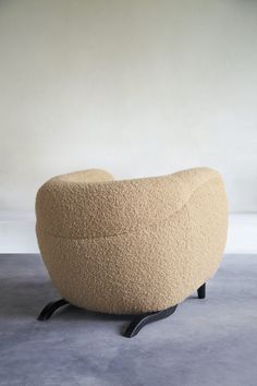 a chair made out of sheep's wool sitting on top of a cement floor