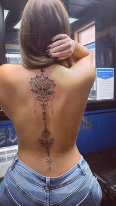 the back of a woman's body with tattoos on it