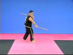 a man holding a baseball bat while standing on top of a pink floor in front of a blue wall