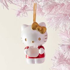 a hello kitty ornament hanging from a pink christmas tree with glittery decorations